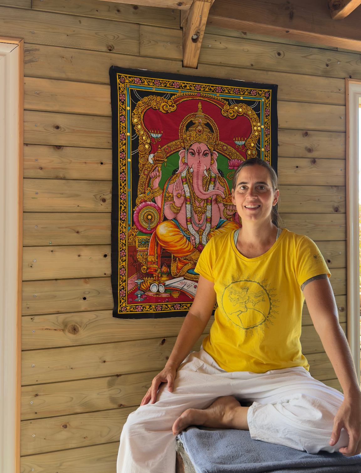 Sylvia Narayani Knabe seated in front of Ganesha